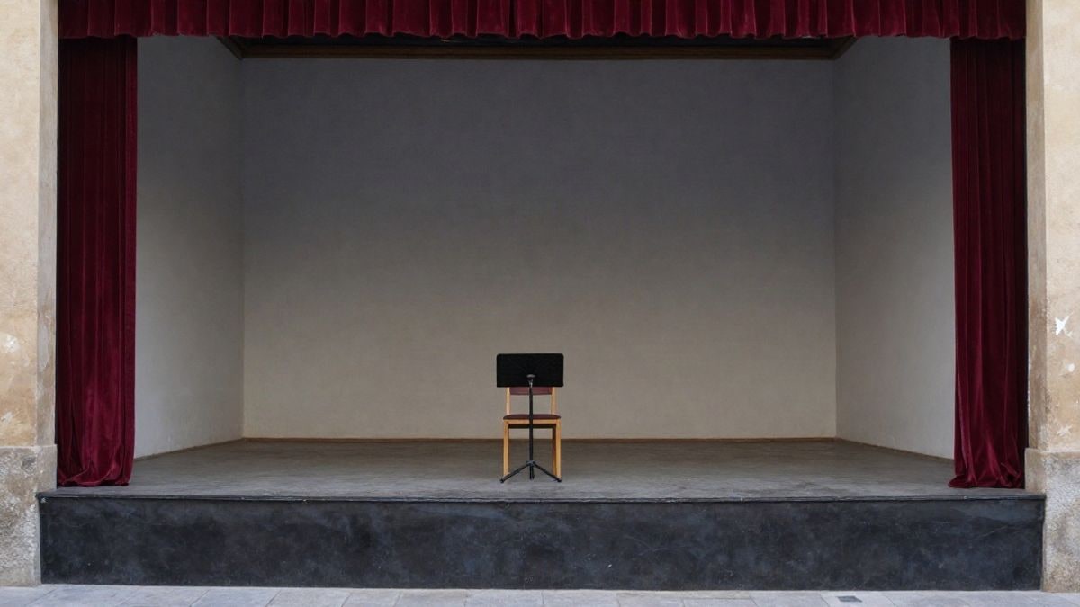 Imagen ilustrativa: escenario vacío de un pequeño teatro con una silla y un atril