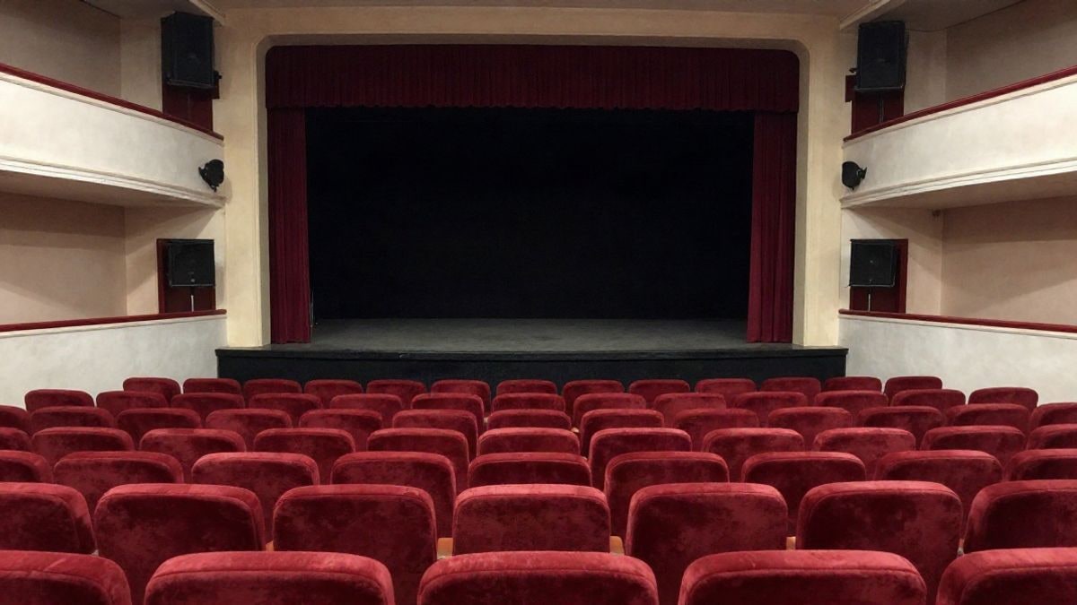 Illustrative image: red seats and stage with curtain in an empty municipal auditorium