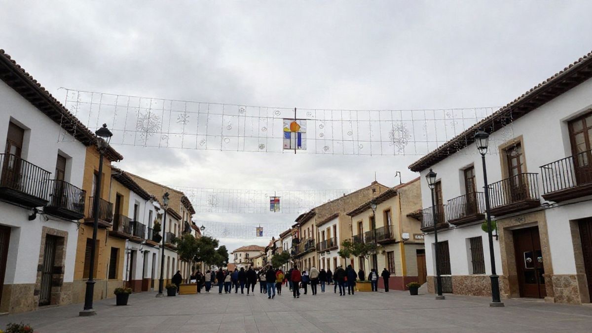 Imagen ilustrativa: plaza de un municipio español engalanada con adornos festivos, vista desde el suelo hacia el cielo