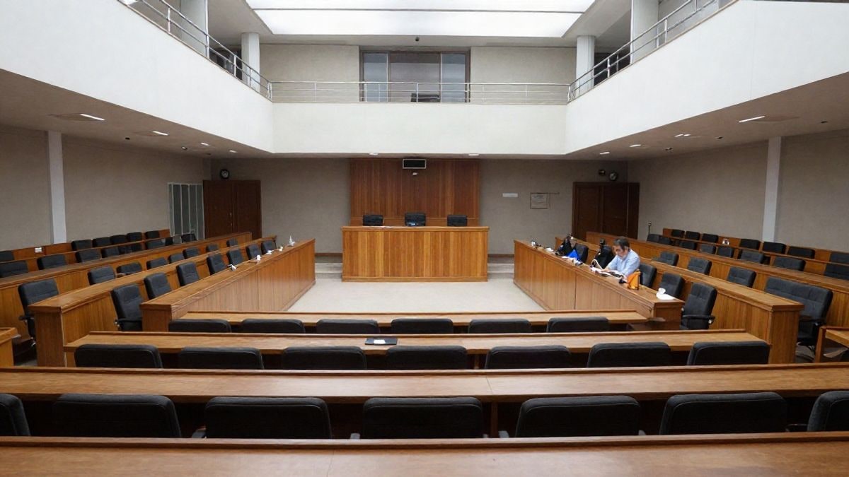 Imagen ilustrativa: sala de plenos municipal vacía con filas de asientos y tribuna de madera