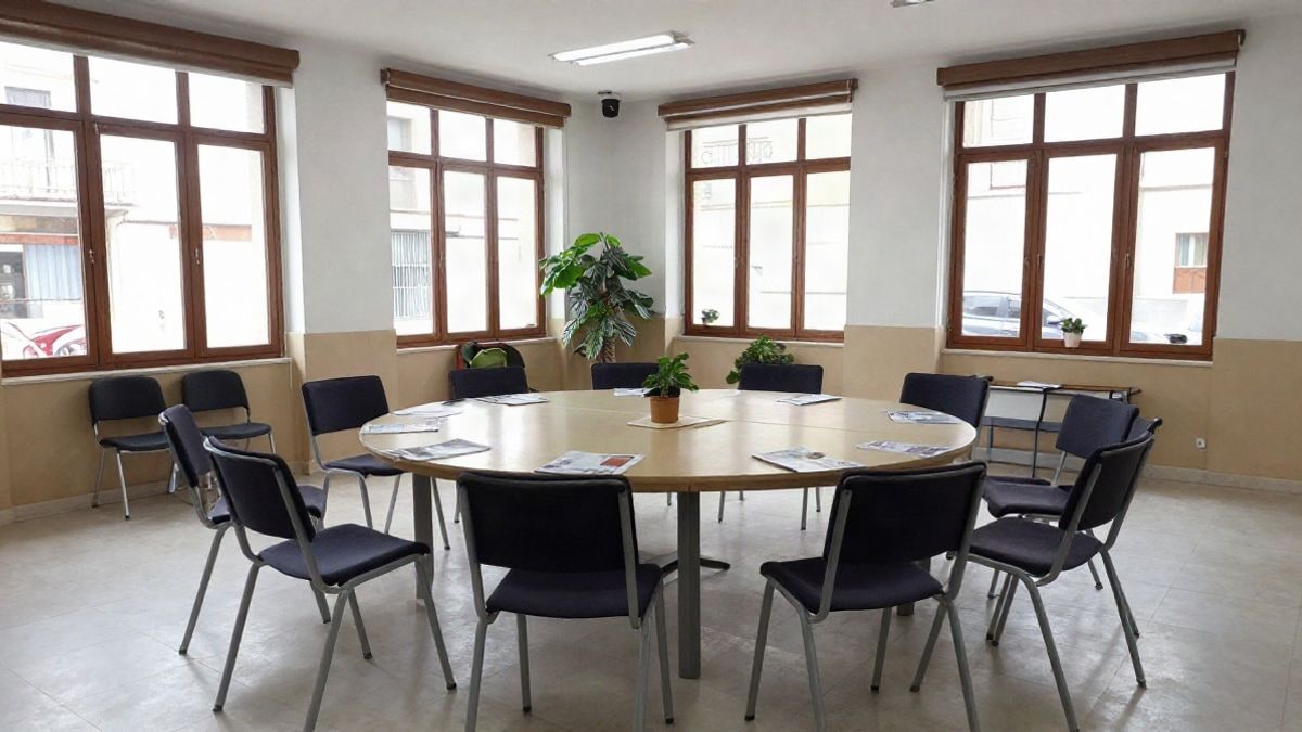 Imagen ilustrativa: sala polivalente con sillas en círculo y luz natural, sin personas