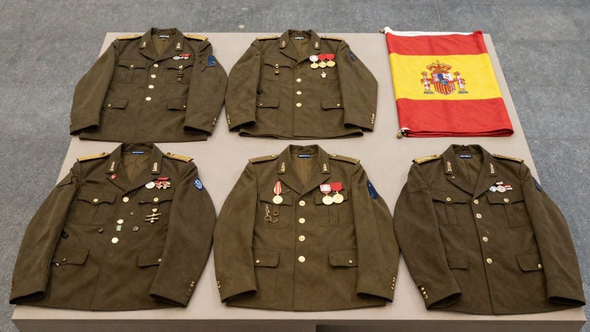 Imagen ilustrativa: vista cenital de uniformes militares antiguos y condecoraciones sobre una mesa de museo