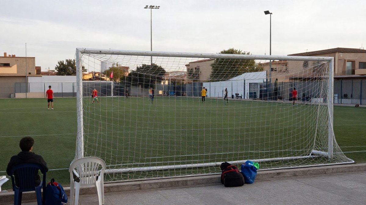 Imagen ilustrativa: campo de fútbol con portería y red en un complejo deportivo, con gradas vacías y luz de día nublado.