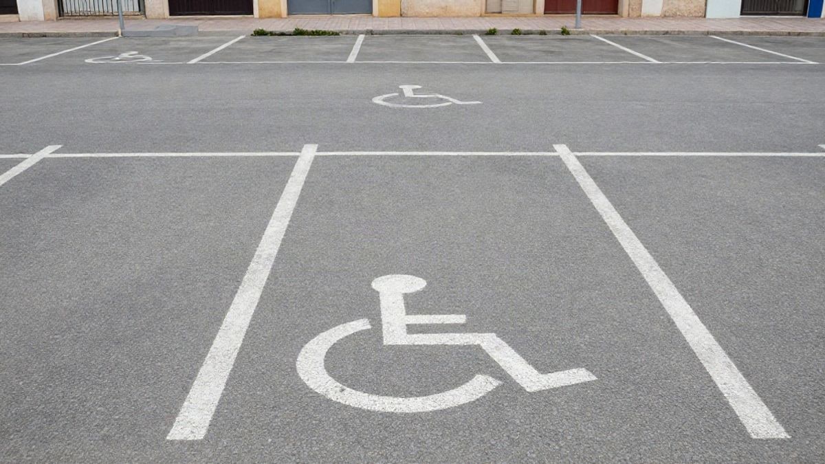 Imagen ilustrativa: plazas de aparcamiento accesible señalizadas con el símbolo de silla de ruedas en un aparcamiento genérico