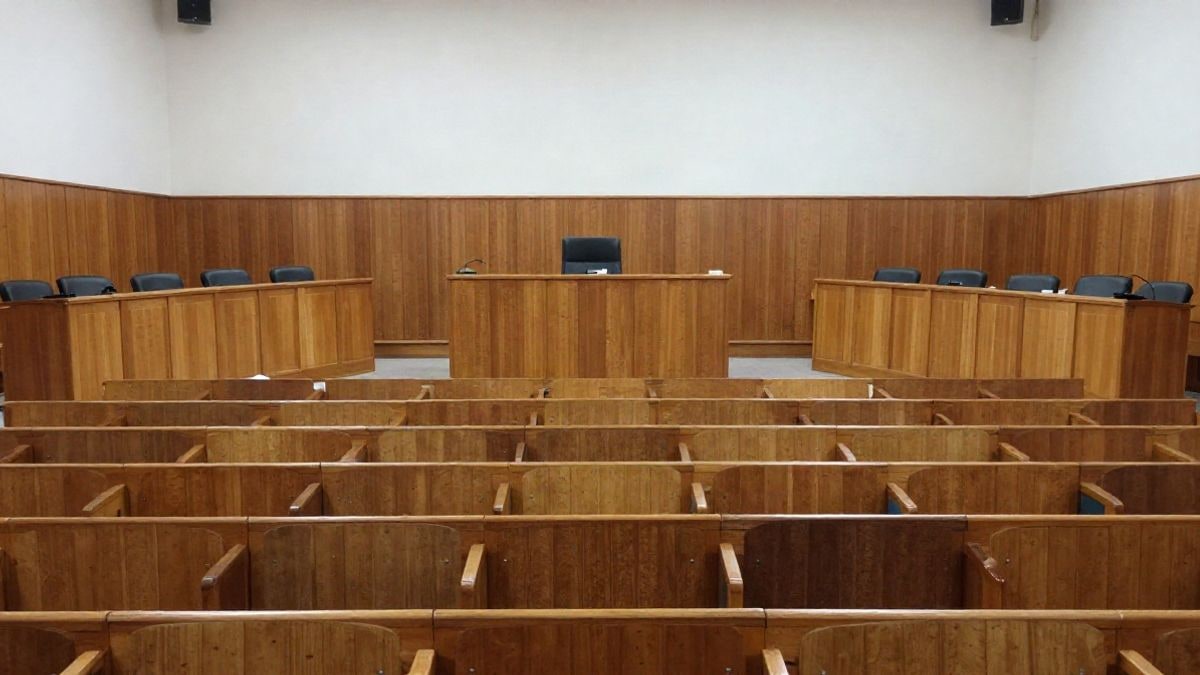 Imagen ilustrativa: sala de plenos municipal vacía con escaños de madera y atril