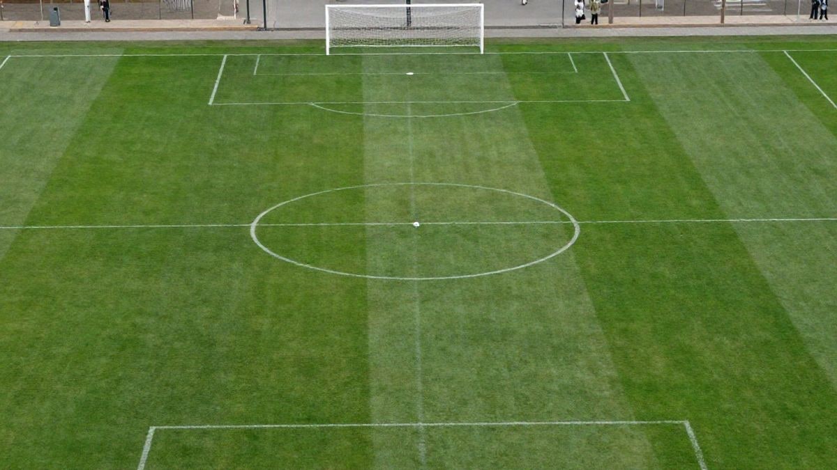 Imagen ilustrativa: vista cenital de un campo de fútbol con el balón en el centro y porterías a los lados