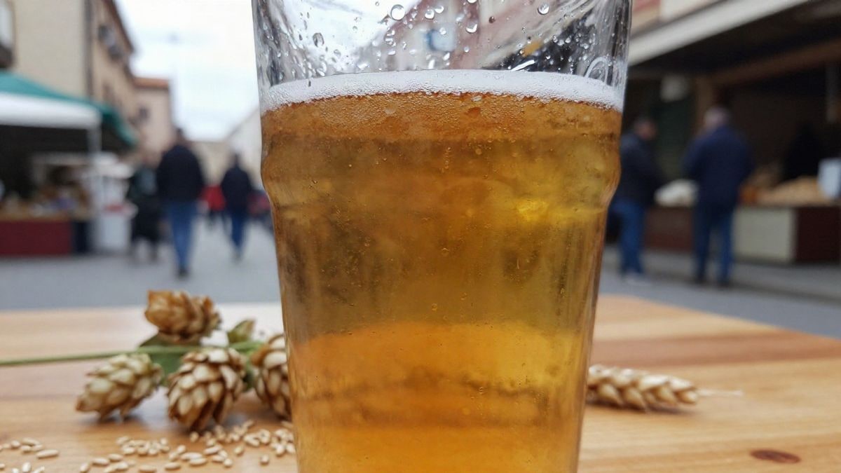 Imagen ilustrativa: primer plano de un vaso de cerveza artesana con gotas de condensación sobre una mesa de madera