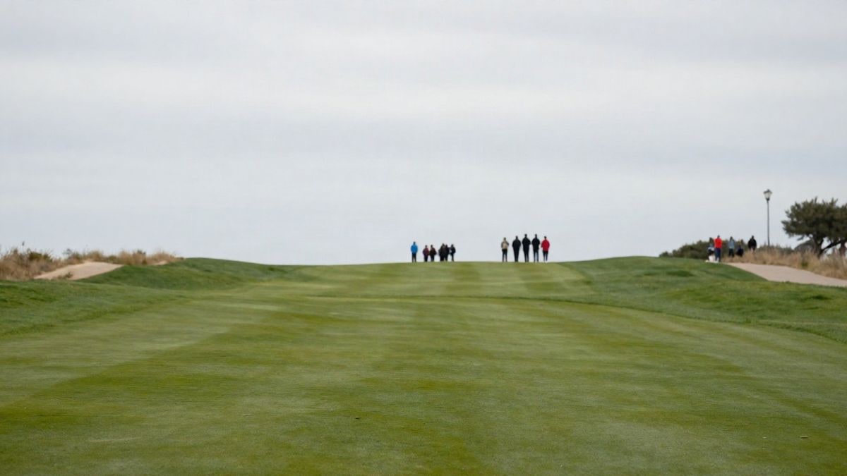 Imagen ilustrativa: campo de golf vacío con bandera al fondo bajo un cielo nublado