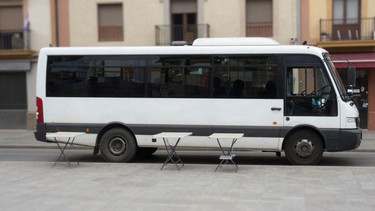 Imagen ilustrativa: autobús de donación de sangre aparcado en una plaza de un pueblo español, con mesas y sillas junto a la puerta