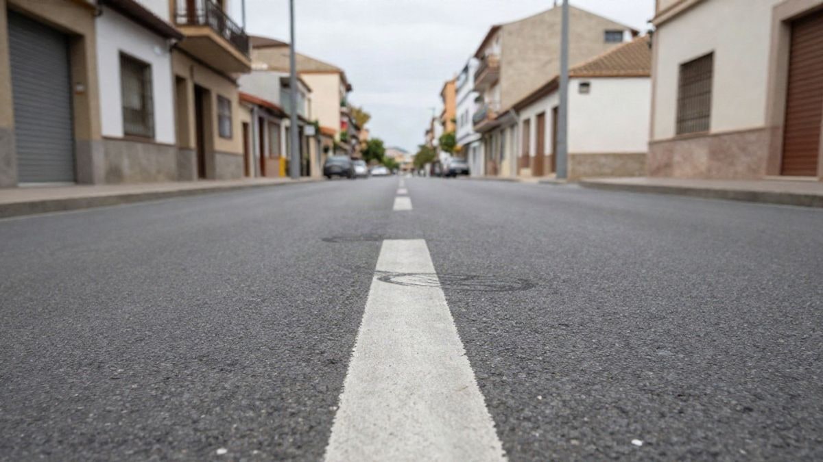 Imagen ilustrativa: calle urbana vacía con línea pintada en el asfalto y fachadas residenciales al fondo