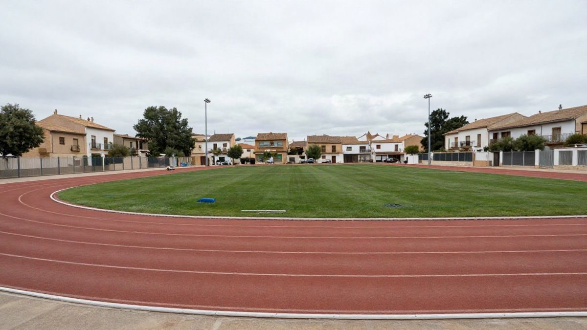Imagen ilustrativa: una pista deportiva municipal vacía en un entorno rural, con el cielo nublado y vegetación al fondo.