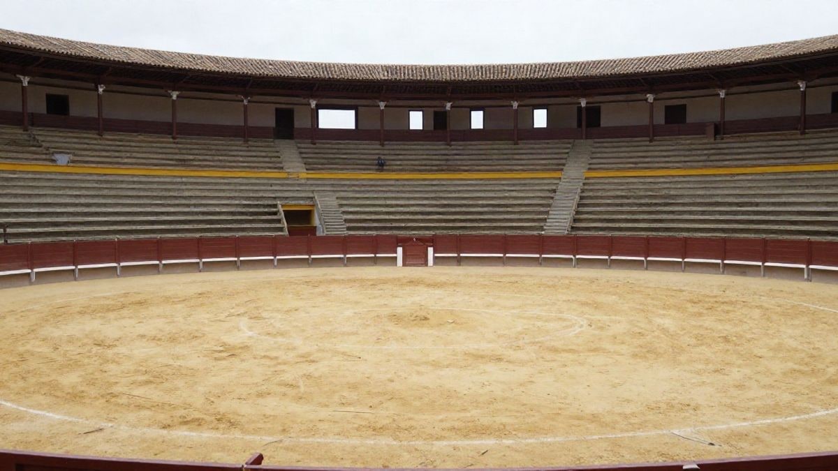 Illustrative image: interior of a bullring with sand and empty stands under side light