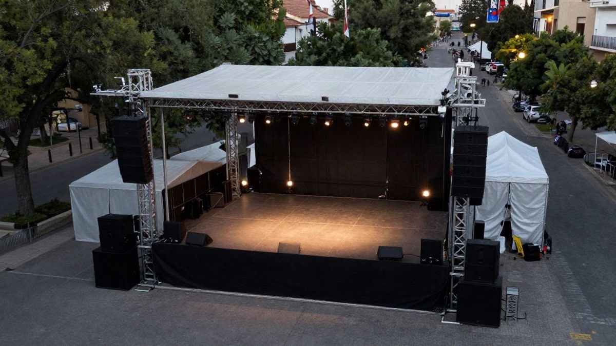 Imagen ilustrativa: vista cenital de un escenario de festival al aire libre en un parque, sin público