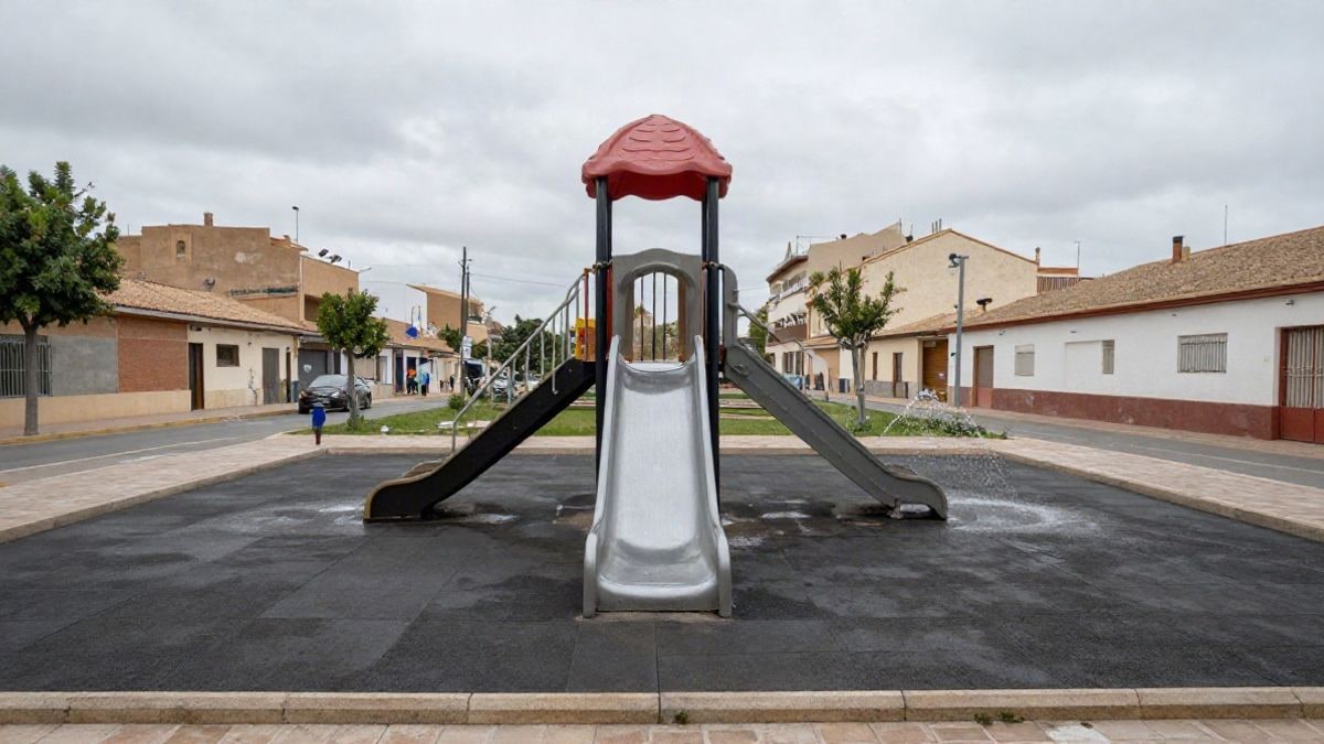 Imagen ilustrativa: un parque infantil con tobogán y juegos de agua en un día nublado, sin personas