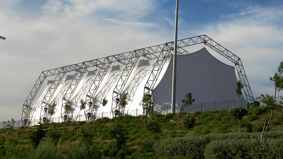 Auditorium Miguel Ríos with white stretched cover and lighting tower on a landscaped hill