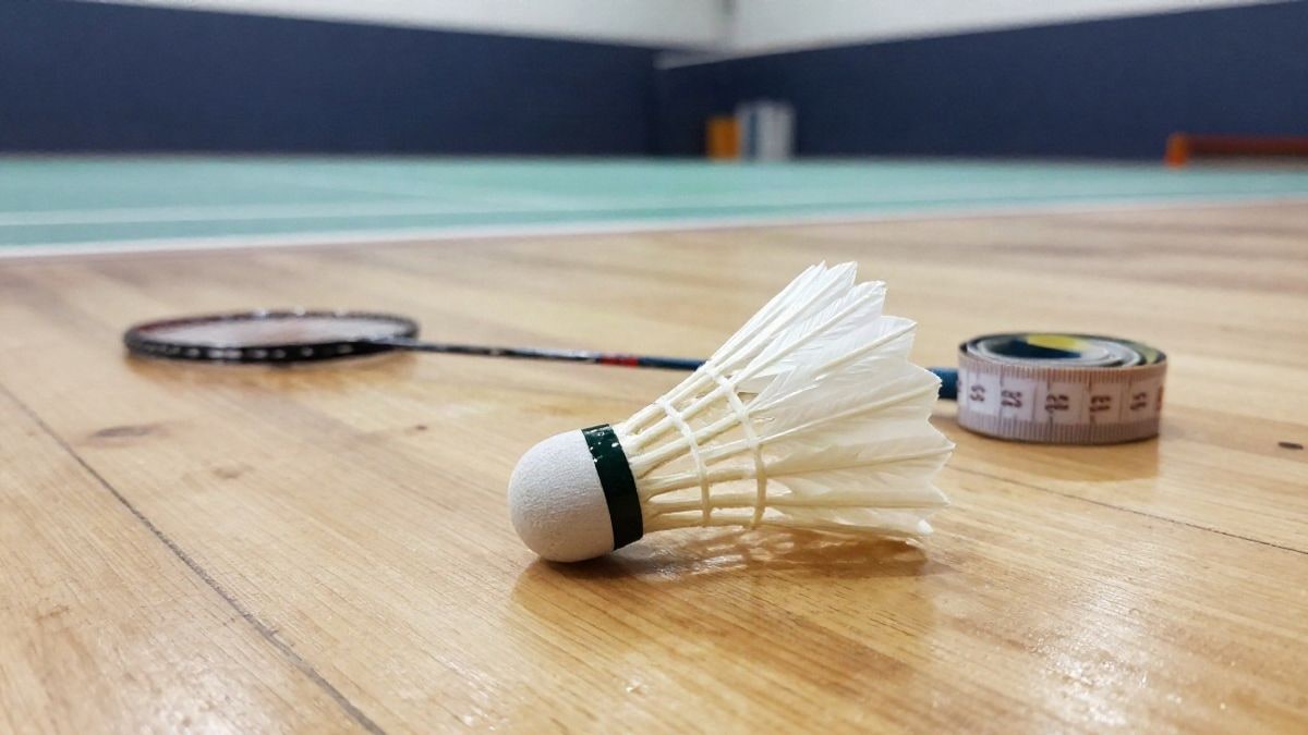 Imagen ilustrativa: primer plano de un volante de bádminton sobre el suelo de un pabellón deportivo