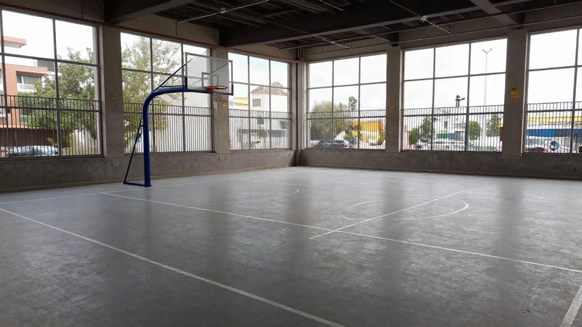 Imagen ilustrativa: pista polideportiva municipal vacía con luz lateral de ventana