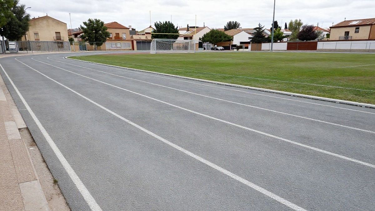 Imagen ilustrativa: pista de atletismo vacía y campo de fútbol con porterías en un día nublado.