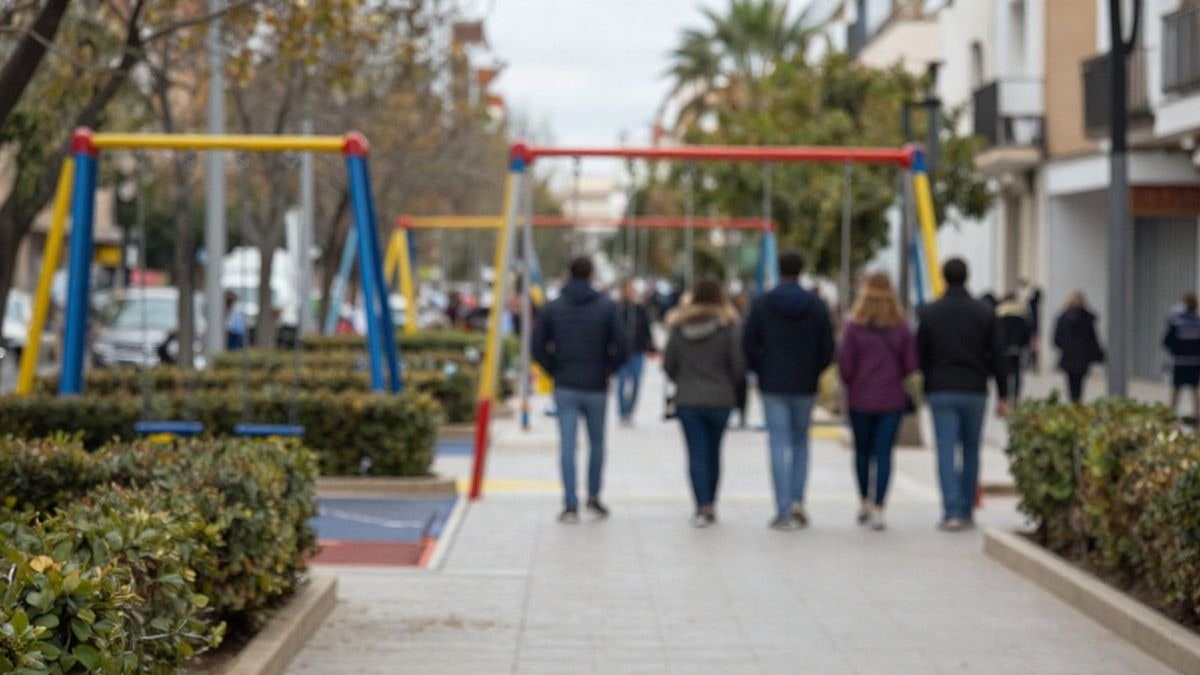 Imagen ilustrativa: vista cenital de un parque infantil renovado con multijuegos, columpios y pavimento de seguridad en un jardín urbano