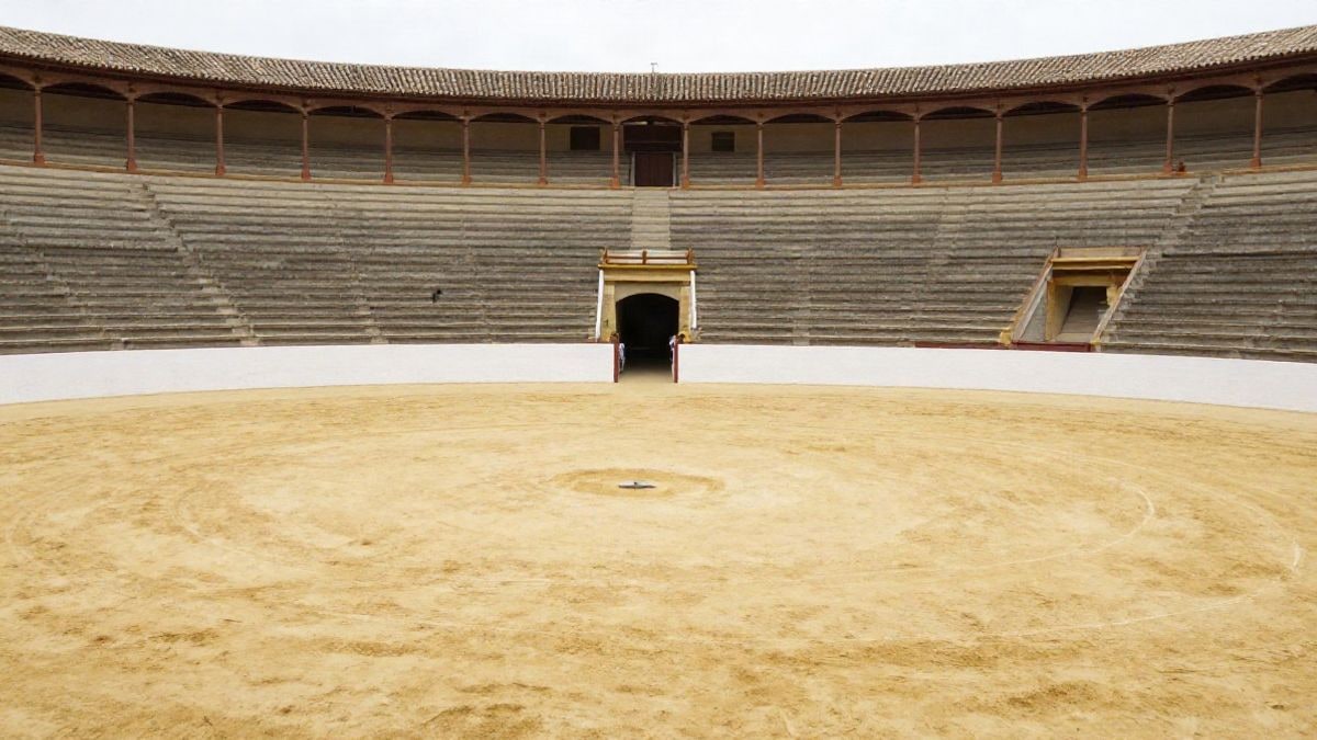 Imagen ilustrativa: una plaza de toros vacía vista desde el ruedo, con la barrera y las gradas al fondo