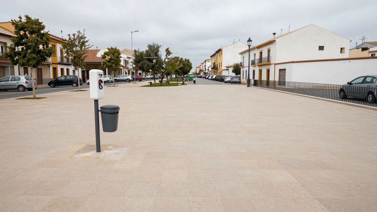 Imagen ilustrativa: paseo de un parque urbano con dispensador de bolsas para excrementos caninos y una papelera junto al camino