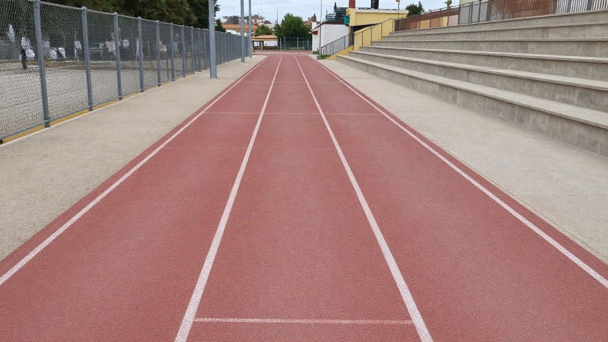 Imagen ilustrativa: pista de atletismo vacía con líneas que convergen hacia una meta