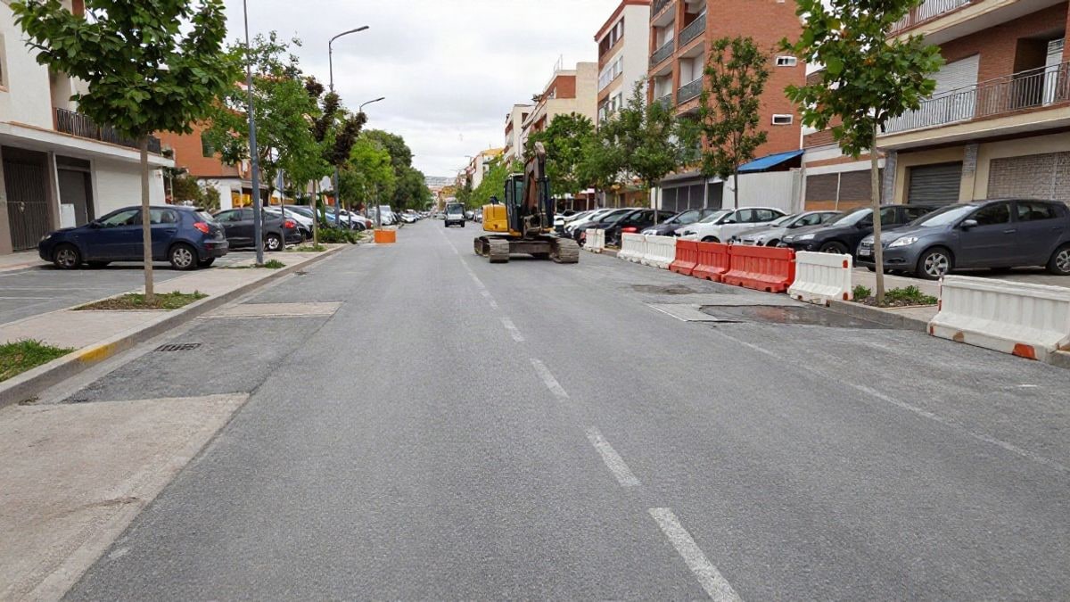 Imagen ilustrativa: obras de un aparcamiento en superficie con maquinaria y barreras en una calle residencial