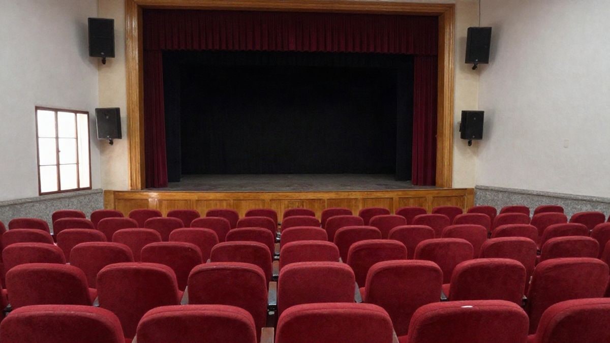 Imagen ilustrativa: interior de un teatro municipal con butacas vacías y escenario con telón cerrado
