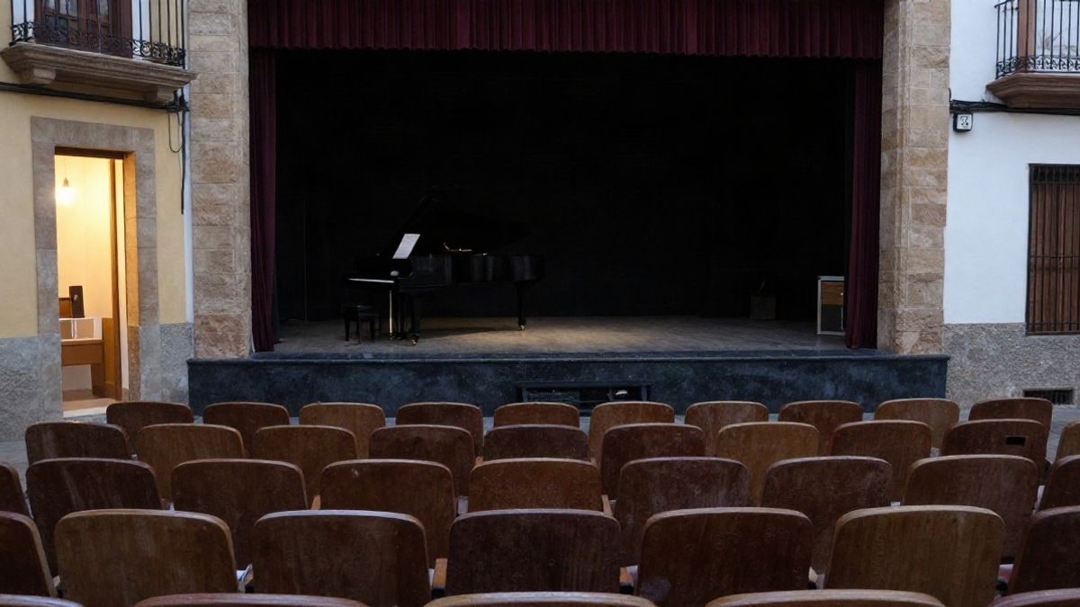 Imagen ilustrativa: interior de un teatro con butacas vacías y un piano en el escenario