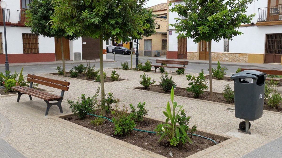 Imagen ilustrativa: zona ajardinada con arbustos, bancos y pavimento permeable en una calle española